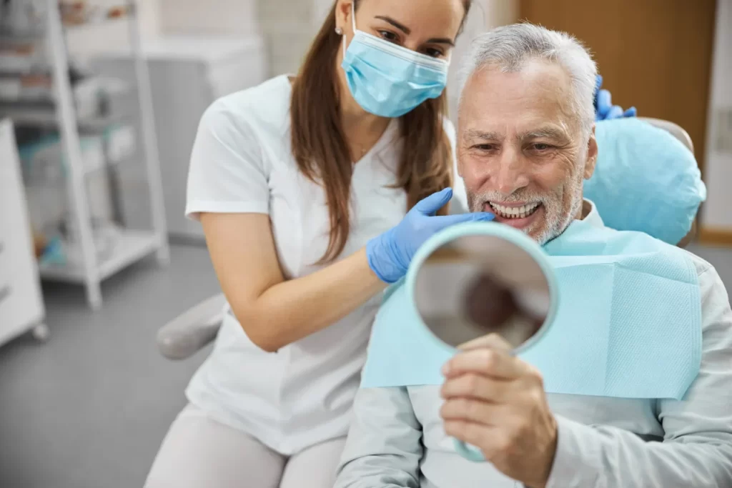 Older adult smiling confidently after adapting to new dental prosthesis.