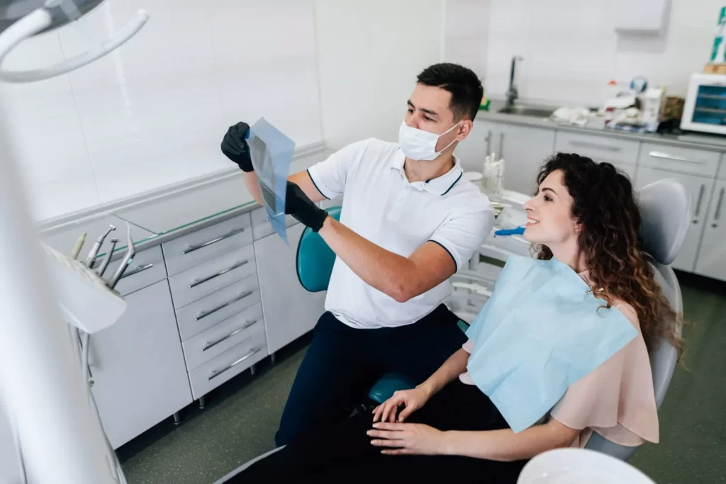 Dentist reviewing X-ray with patient to compare different types of dental fillings for treatment.