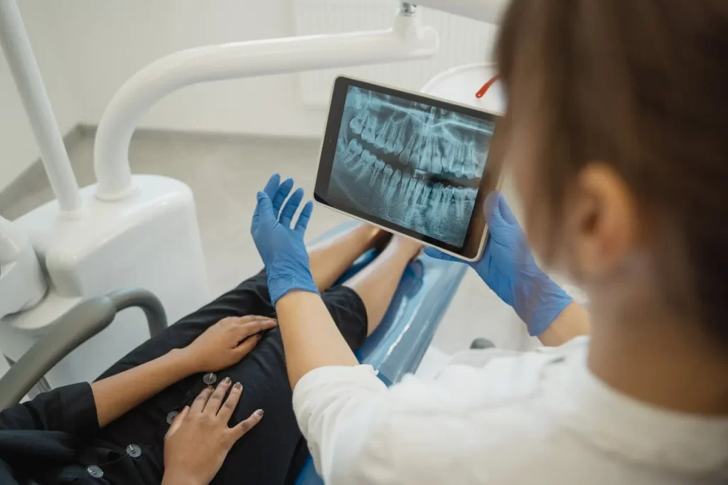 Reviewing a dental X-ray on a tablet as part of a cosmetic dentistry consultation.
