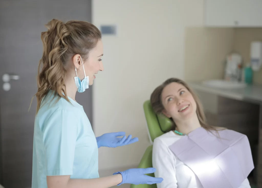 Dentist discussing a treatment plan with a smiling patient in a dental chair during a consultation.